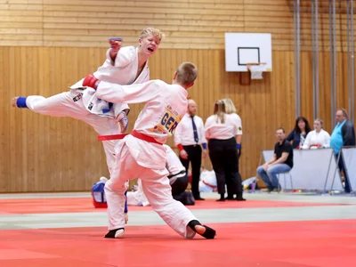 Auf dem Weg zur Goldmedaille punktet Elias Wiedemann (blauer Gürtel) mit einem Handkantenschlag zum Kopf.