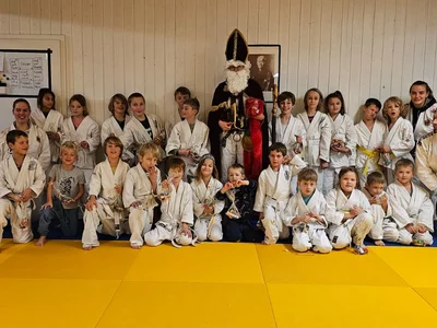 Umringt von den sportlichen Kindern und Trainerinnen und Trainern steht der Nikolaus im Dojo der Ju-Jutsu-Abteilung des TSV Bergen.