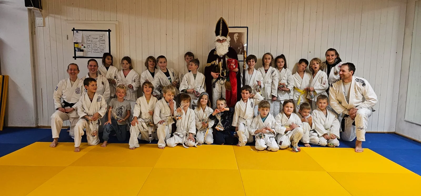Umringt von den sportlichen Kindern und Trainerinnen und Trainern steht der Nikolaus im Dojo der Ju-Jutsu-Abteilung des TSV Bergen.