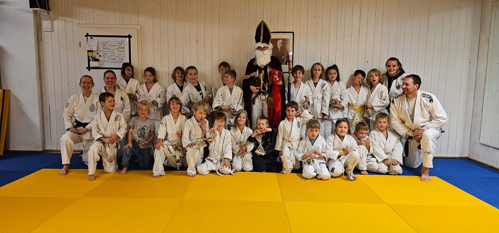 Umringt von den sportlichen Kindern und Trainerinnen und Trainern steht der Nikolaus im Dojo der Ju-Jutsu-Abteilung des TSV Bergen.